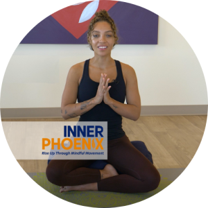 Instructor of Inner Phoenix videos sits on yoga mat.